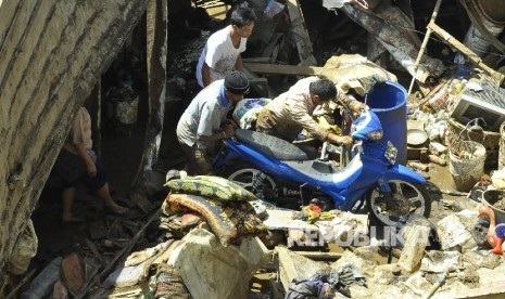   Sejumlah warga memindahkan kendaraan motor pasca banjir bandang di Tarogong Kidul, Kabupaten Garut, Kamis (22/9).