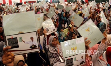 Sejumlah warga memperlihatkan sertifikat tanah usai dibagikan saat Penyerahan Sertifikat Tanah Untuk Rakyat di Makassar, Sulawesi Selatan, Kamis (28/12).