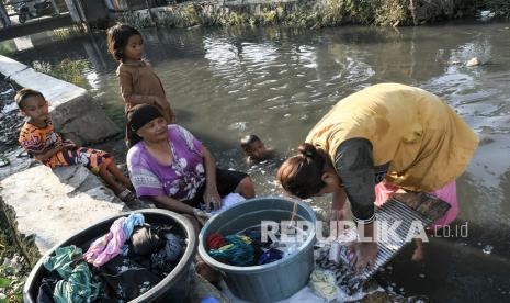 Sejumlah warga mencuci pakaian di aliran kali Blencong, Sukatani, Kabupaten Bekasi, Jawa Barat, Kamis (26/8/2021). Menurut warga, sudah 6 bulan kualitas air tanah di wilayah tersebut berwarna hitam dan tidak layak konsumsi. 