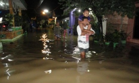 Sejumlah warga menerobos genangan banjir akibat luapan Sungai Bengawan Solo di Desa Ledokwetan, Kecamatan Kota, Bojonegoro, Jatim.