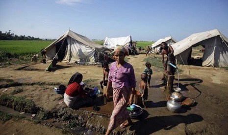 Sejumlah warga mengambil air di sebuah kamp pengungsi bagi warga muslim yang terlantar akibat aksi kekerasan awal tahun ini di luar Sittwe, Myanmar,  Selasa (30/10).   (Soe Zeya Tun/Reuters)