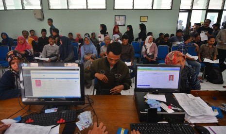 Sejumlah warga mengantre menunggu panggilan petugas Dinas kependudukan dan pencatatan sipil (Disdukcapil) untuk mengambil KTP elektronik.