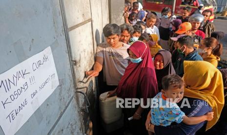 Sejumlah warga mengantre untuk membeli minyak goreng curah di sebuah agen penjualan minyak goreng di kota Temanggung, Jawa Tengah, Rabu (30/3/2022). Untuk dapat membeli minyak goreng curah seharga Rp15 ribu per liter, warga harus menunjukan fotokopi KTP dan hanya boleh membeli satu jeriken per orang.