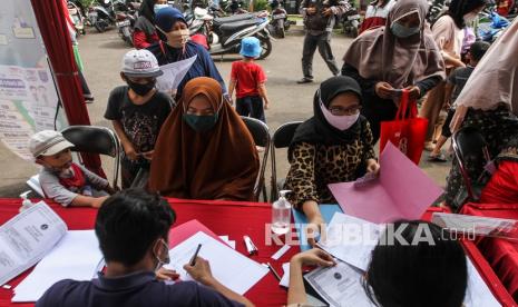 Sejumlah warga mengantre untuk mendaftar pembuatan KIA di Kantor Kecamtan Tapos, Depok, Jawa Barat, Jumat (17/12/2021). Dinas Kependudukan dan Pencatatan Sipil (Dukcapil) Kota Depok menggelar gebyar layanan penerbitan Kartu Identitas Anak (KIA) secara gratis dan langsung jadi selama 2 hari tersebut untuk memenuhi target sekitar 292.860 anak yang belum memiliki KIA.