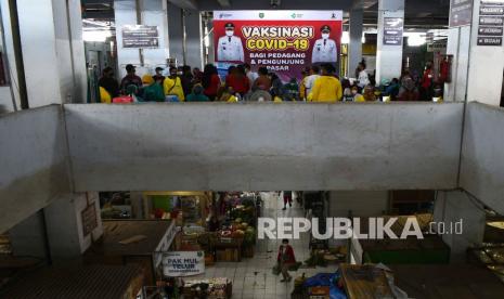 Sejumlah warga mengantre untuk mendapatkan suntikan vaksin COVID-19 saat vaksinasi massal bagi pedagang dan pengunjung di Pasar Besar Kota Madiun, Jawa Timur, Jumat (15/10/2021). Pemkot Madiun menggelar vaksinasi massal di lokasi yang banyak dikunjungi warga tersebut guna mengejar capaian 100 persen vaksinasi COVID-19 di daerah yang saat ini vaksinasinya mencapai 93,12 persen dosis 1 dan 57,68 persen dosis 2 dari total sasaran 197.000 orang.