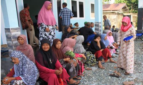 Sejumlah warga mengantre untuk pengambilan Zakat Infaq dan Shadakah (ZIS) di Aula Kantor Desa Cot Seulamat, Kecamatan Samatiga, Aceh Barat, Aceh,Ahad (12/4/2020). Pemerintah Kabupaten Aceh Barat melalui Badan Baitul Mal menyalurkan Rp8.582.250.000 kepada 13.519 orang yang terdiri dari fakir, miskin, fakir ozor dan amil yang tersebar di 12 Kecamatan di Kabupaten setempat