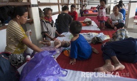  Sejumlah warga mengasuh anaknya di pengungsian menyusul peningkatan aktifitas Gunung Agung di Desa Duda Timur, Karangasem, Bali, Selasa (3/7). 