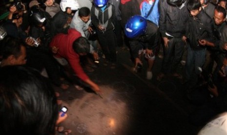 Sejumlah warga mengerubuti percikan darah yang telah ditutupi pasir di lokasi baku tembak antara Densus 88 dengan terduga teroris di Jl Veteran, Tipes, Solo, Jumat (31/8) malam.