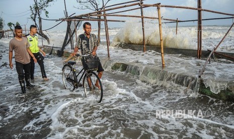 Sejumlah warga menghindari gelombang laut yang mengenai garis pantai di Pantaisari, Pekalongan, Jawa Tengah, Jumat (1/12). 