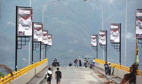 Sejumlah warga menikmati suasana pagi di ujung jembatan kuning yang rusak akibat diterjang tsunami di Pantai Talise Palu, Sulawesi Tengah, Sabtu (13/10).