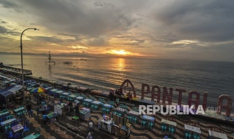 Sejumlah warga menikmati sunset atau matahari terbenam akhir tahun 2019 di Pantai Ampenan, Mataram, NTB, Selasa (31/12/2019).