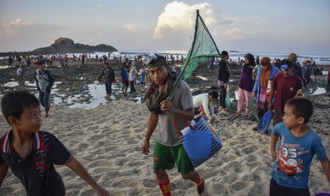 Festival Pesona Bau Nyale: Sejumlah warga meninggalkan pantai usai menangkap Nyale (cacing laut warna-warni) pada Festival Pesona Bau Nyale 2019 di pantai Seger Kawasan Ekonomi Khusus (KEK) Mandalika yang dikelola Indonesia Tourism Development Corporation (ITDC) di Kuta, Praya, Lombok Tengah, NTB, Senin (25/2/2019).