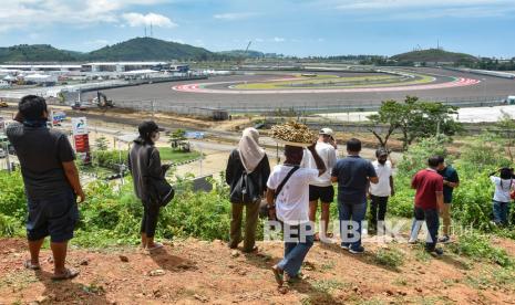 Sejumlah warga menonton sesi tes pramusim MotoGP 2022 dari atas bukit sekitar Pertamina Mandalika International Street Circuit di KEK Mandalika, Desa Kuta, Kecamatan Pujut, Praya, Lombok Tengah, NTB, Sabtu (12/2/2022). Warga antusias menyaksikan tes pramusim MotoGP 2022 yang diikuti 24 pembalap di sirkuit yang memiliki panjang 4,32 km dengan 17 tikungan itu. 