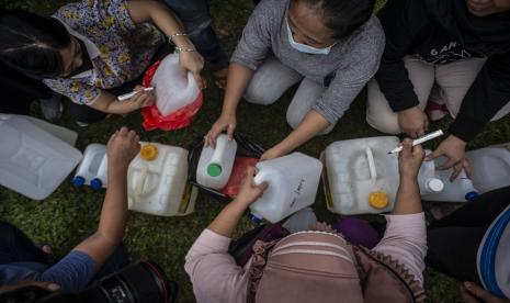 Sejumlah warga menuliskan nama mereka di jerigen saat membeli minyak goreng curah dalam program Distribusi Minyak Goreng HET di kawasan Pasar Senen Blok III, Jakarta, Kamis (17/3/2022). Harga minyak goreng curah tersebut dijual Rp14.500,- per kilogram untuk pedagang dan Rp15.500,- untuk masyarakat umum atau penggunaan pribadi.