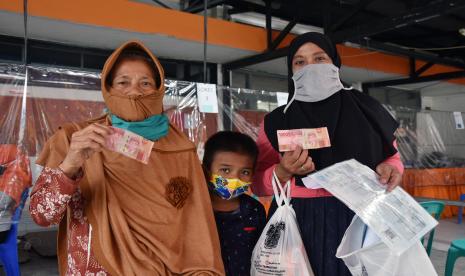 Sejumlah warga menunjukan uang tunai Bantuan Sosial Tunai (BST) di Kantor POS Pekanbaru, Riau, Senin (19/10). Ketua Satgas Pemulihan dan Transformasi Ekonomi Budi Gunadi Sadikin mengungkapkan, salah satu jurus yang dijalankan pemerintah untuk mendongkrak PDB di akhir tahun adalah memaksimalkan belanja pemerintah. 