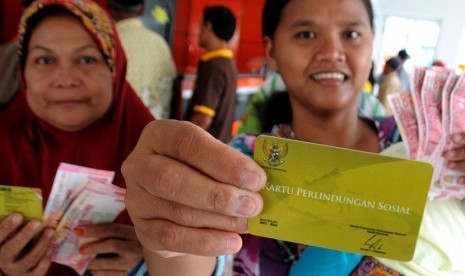 Sejumlah warga menunjukkan uang yang diterimanya usai antre pencairan dana Program Simpanan Keluarga Sejahtera (PSKS) di Kantor Pos Indonesia Cabang Pancoran Mas, Depok, Jawa Barat, Rabu (15/4).(Indrianto Eko Suwarso)