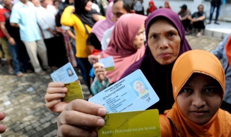 Sejumlah warga menunjukkan uang yang diterimanya usai antre pencairan dana Program Simpanan Keluarga Sejahtera (PSKS) di Kantor Pos Indonesia Cabang Pancoran Mas, Depok, Jawa Barat, Rabu (15/4).(Indrianto Eko Suwarso)