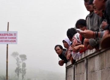 Sejumlah warga menyaksikan aktivitas kawah Timbang di kawasan dataran tinggi Dieng yang terus mengeluarkan gas CO2 di Dukuh Simbar, Sumberrejo, Batur, Banjarnegara, Jateng, Senin (30/5).