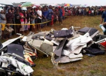 Sejumlah warga menyaksikan bagian badan pesawat Merpati MA-60 yang hancur setelah jatuh sebelum mendarat di Bandara Kaimana, Papua Barat, Minggu (8/5).