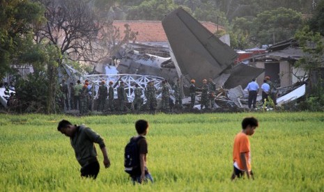     Sejumlah warga menyaksikan bangkai pesawat Fokker 27 yang jatuh di komplek Rajawali, Lapangan Udara Halim Perdana Kusuma, Jakarta, Kamis (21/6).  (Adhi Wicaksono/Republika)