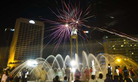  Sejumlah warga menyaksikan kembang api pada malam takbiran di kawasan Bundaran Hotel Indonesia, Jakarta, Sabtu (18/8) malam. (Ismar Patrizki/Antara)