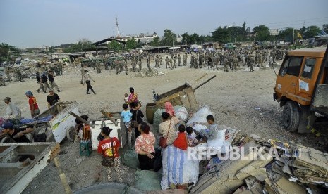 Sejumlah warga menyaksikan saat petugas membongkar bangunan liar di Kawasan Taman Bersih, Manusiawi dan Berwibawa (BMW), Kecamatan Tanjung Priok, Jakarta, Selasa (1/8).