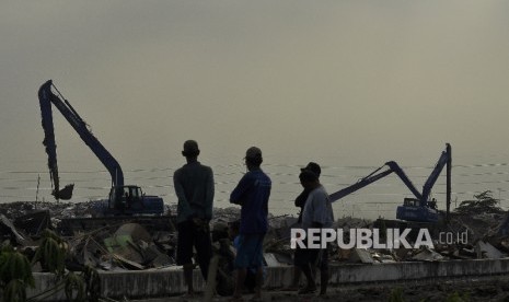 Sejumlah warga menyaksikan saat petugas membongkar bangunan liar di Kawasan Taman Bersih, Manusiawi dan Berwibawa (BMW), Kecamatan Tanjung Priok, Jakarta, Selasa (1/8).