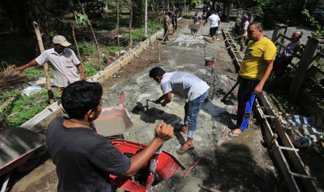 Sejumlah warga menyelesaikan pembuatan tembok pelindung batas badan jalan dari anggaran dana desa di Desa Alue Raya, Kecamatan Samatiga, Aceh Barat, Aceh, Ahad (7/8/2022). Pemerintah sejak 2015-2022 telah menyalurkan dana desa sebesar Rp468 triliun yang dimanfaatkan untuk berbagai pembangunan desa. 