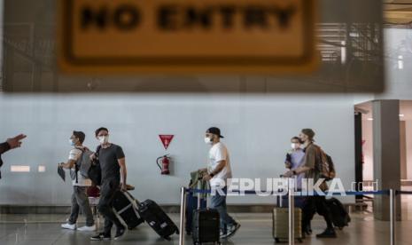 Sejumlah Warga Negara Asing (WNA) berjalan di area kedatangan internasional setibanya di Terminal 3 Bandara Internasional Soekarno-Hatta, Tangerang, Banten, Senin (29/11/2021). Pemerintah memberlakukan larangan WNA dari Afrika Selatan, Botswana, Namibia, Zimbabwe, Lesotho, Mozambique, Eswatini, Malawi, Angola, Zambia dan Hongkong untuk masuk ke wilayah Indonesia guna mencegah masuknya varian COVID-19 B.1.1.529 atau Omicron dan mewajibkan karantina selama 14 hari bagi penumpang yang berkunjung dari negara tersebut, sedangkan penumpang dari selain negara tersebut wajib karantina selama tujuh hari. 