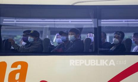 Sejumlah warga negara asing (WNA) duduk di dalam bus yang akan menuju tempat karantina setibanya di Bandara Internasional Soekarno Hatta, Tangerang, Banten, Sabtu (30/1/2021). Pemerintah Indonesia kembali memperpanjang larangan masuknya WNA hingga 8 Februari 2021 kecuali WNA pemegang visa diplomatik, visa dinas kunjungan resmi pejabat asing setingkat menteri ke atas, izin tinggal diplomatik dan izin tinggal dinas serta Kartu Izin Tinggal Terbatas (KITAS) dan Kartu Izin Tinggal Tetap (KITAP).