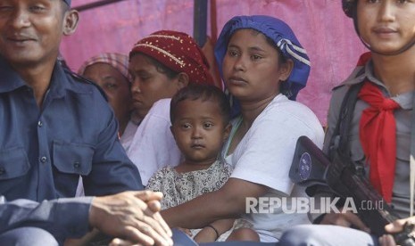 Sejumlah warga Rohingya menunggu di truk Polisi Myanmar untuk dibawa kembali menuju penampungan sementara yang didirika pemerintah di Desa ManSi dekat Sittwe, Negara Bagian Rakhinne, Myanmar, Rabu (21/11). 