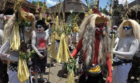 Sejumlah warga yang berbusana mahluk menyeramkan berjalan berkeliling kampung membawa sarana upacara dalam ritual Ngerebeg di Desa Tegallalang, Gianyar, Bali, Rabu (16/3).