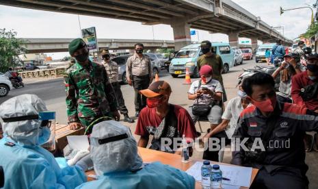 Sejumlah warga yang terjaring razia protokol kesehatan mengikuti rapid test oleh petugas medis di Kalimalang, Bekasi, Jawa Barat, Selasa (29/12/2020). Tim Gabungan dari TNI, Polri dan Satpol PP melakukan rapid test kepada warga yang terjaring razia protokol kesehatan untuk mencegah penyebaran wabah COVID-19. 