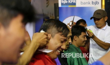 Sejumlah wartawan peliput PON XIX potong rambut bersama-sama di booth cukur rambut Bank BJB di Media Center Utama (MCU) di Trans Hotel, Kota Bandung, Selasa (22/9). Kegiatan tersebut untuk menyemarakan PON XIX. (Republika/Edi Yusuf)