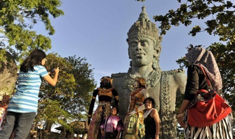 Sejumlah wisatawan berfoto di depan potongan patung Wisnu yaitu bagian dari patung Garuda Wisnu Kencana (GWK), Badung, Bali, Kamis (22/8). 