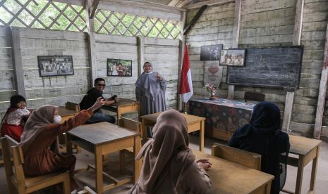 Sejumlah wisatawan berfoto di ruang kelas replika Sekolah Laskar Pelangi di Desa Lenggang, Belitung Timur, Kepulauan Bangka Belitung, Ahad (22/5/2022). Objek wisata Replika Sekolah Laskar Pelangi yang pernah digunakan untuk lokasi pembuatan film tersebut menjadi destinasi wisata favorit di Belitung Timur yang ramai dikunjungi pada hari libur. 