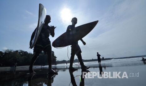 Sejumlah wisatawan berjalan dengan membawa papan surfing di Pantai Batu Karas, Kabupaten Pangandaran, Jawa Barat, Rabu (17/8). (Mahmud Muhyidin)