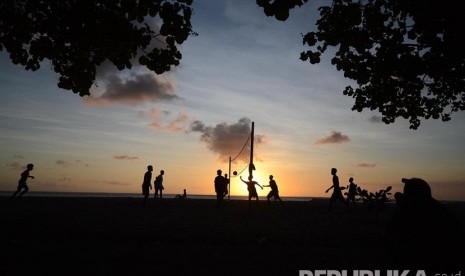 Sejumlah wisatawan bermain volly saat sunset di pantai Kuta yang merupakan area kawasan  hotel Patra Jasa, Bali, Rabu (18/5). (Republika/Musiron) 