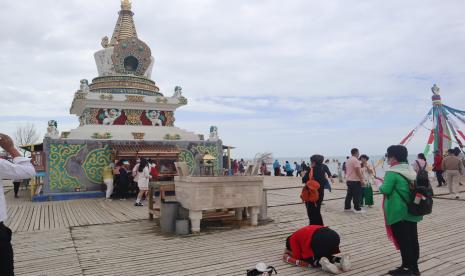 Sejumlah wisatawan bersembahyang di depan sesembahan di kawasan Danau Qinghai di Provinsi Qinghai, China, Senin (11/7/2022). Danau Qinghai yang berada di atas ketinggian 3.260 meter dari permukaan laut yang luasnya mencapai 4.543 kilometer persegi di dataran tinggi Tibet itu ramai dikunjungi wisatawan pada musim panas. Gelombang Panas Landa China, Suhu Capai 40 Derajat Celsius 