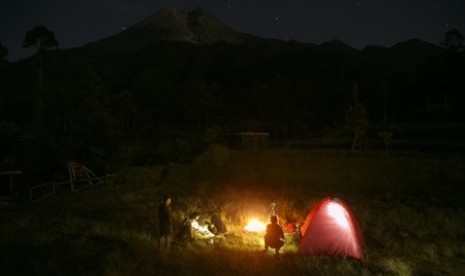 Sejumlah wisatawan mengambil gambar puncak Gunung Merapi di Bukit Klangon, Cangkringan, Sleman, DI Yogyakarta, Jumat (24/5/2019). Balai Penyelidikan dan Pengembangan Teknologi Kebencanaan Geologi (BPPTKG) Yogyakarta merekomendasikan jarak aman melihat fenomena guguran lava pijar Gunung Merapi menjadi obyek wisata adalah radius tiga kilometer dari puncak. 