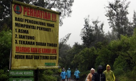 Sejumlah wisatawan menggunakan jas hujan saat mendaki di Gunung Ijen, Banyuwangi, Jawa Timur, Rabu (27/7). 