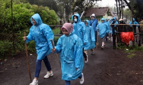 Sejumlah wisatawan menggunakan jas hujan saat mendaki di Gunung Ijen, Banyuwangi, Jawa Timur, Rabu (27/7). 