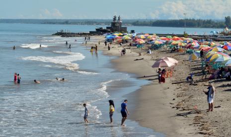 Sejumlah wisatawan menikmati libur lebaran di Pantai Gandoriah, Pariaman, Sumatera Barat, Sabtu (15/5/2021). Wali Kota Pariaman, Genius Umar, mengatakan di daerahnya terjadi peningkatan angka wisatawan dibandingkan libur lebaran Idul Fitri tahun lalu.