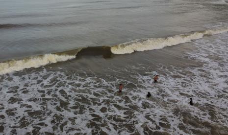 Sejumlah warga mandi di Pantai Tombawatu, Sulawesi Tenggara. Pengunjung pantai diminta mewaspadai cuaca buruk yang akan terjadi Sultra.