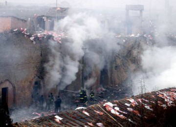 Sejumlah petugas pemadam kebakaran di kota Yichun, Cina, berjuang memadamkan kebakaran akibat ledakan di pabrik kembang api (16/8/2010).