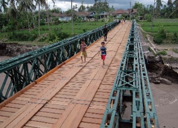 Sejumlah warga melintas di atas jembatan Balley (darurat) yang belum selesai pembangunannya di atas sungai Pabelan desa Adikarto, Mungkid, Magelang, Jateng, Kamis (23/12).