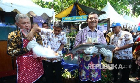 Sekda Jabar Iwa Karniwa (kanan) dan Kepala Dinas Kelautan dan Perikanan Jabar Jafar Ismail menggendong ikan patin pada Festival Lauk Juara dalam acara Gedung Sate Fest, di halaman belakang, Gedung Sate, Kota Bandung, Jumat (16/11). 