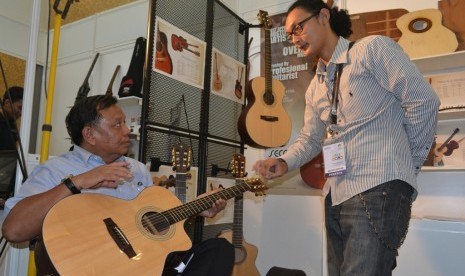 Sekjen Kemenperin Anshari Bukhari mencoba gitar Secco di Pameran Produk Indonesia (PPI), di Bandung, Ahad (29/9). 