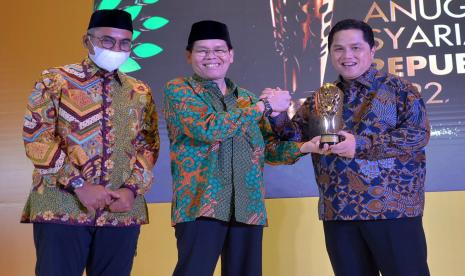 Sekjen MUI Amirsyah Tambunan didampingi Pemimpin Redaksi Republika Irfan Junaidi memberikan piala kepada Ketua Umum Masyarakat Ekonomi Syariah Erick Thohir pada acara Anugerah Syariah Republika 2022 di Jakarta, Selasa (29/11/2022).