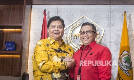 Sekjen PDIP Hasto Kristiyanto (kanan) berjabat tangan dengan Ketua Umum Partai Golkar Airlangga Hartarto (kiri) saat berkunjung untuk melakukan pertemuan di Kantor DPP Golkar, Jakarta, Selasa (20/3).